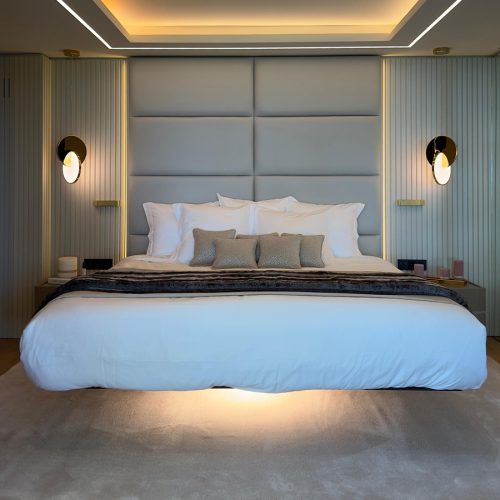Dormitorio principal en vivienda reformada del Maresme con cama flotante de LAGO y cabezal capitonado. Interiorismo de Prada’s Design.