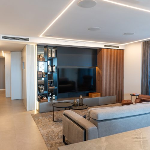 Salón principal con sofá de diseño Italiano, alfombra y mesitas de @Cattelan Italia, sillón de @Pilma, decoración en estanterías de @Luzio