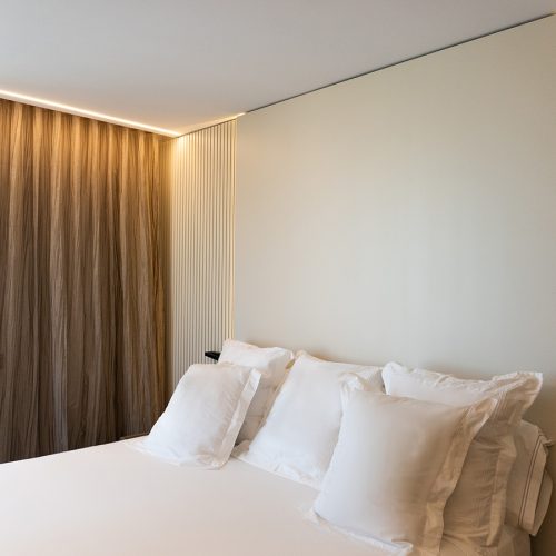 Suite principal con cama de diseño tapizada, cabezal a medida y textiles de @Bassols.